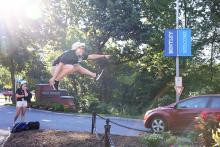 Bentley student wearing white hat jumping in air